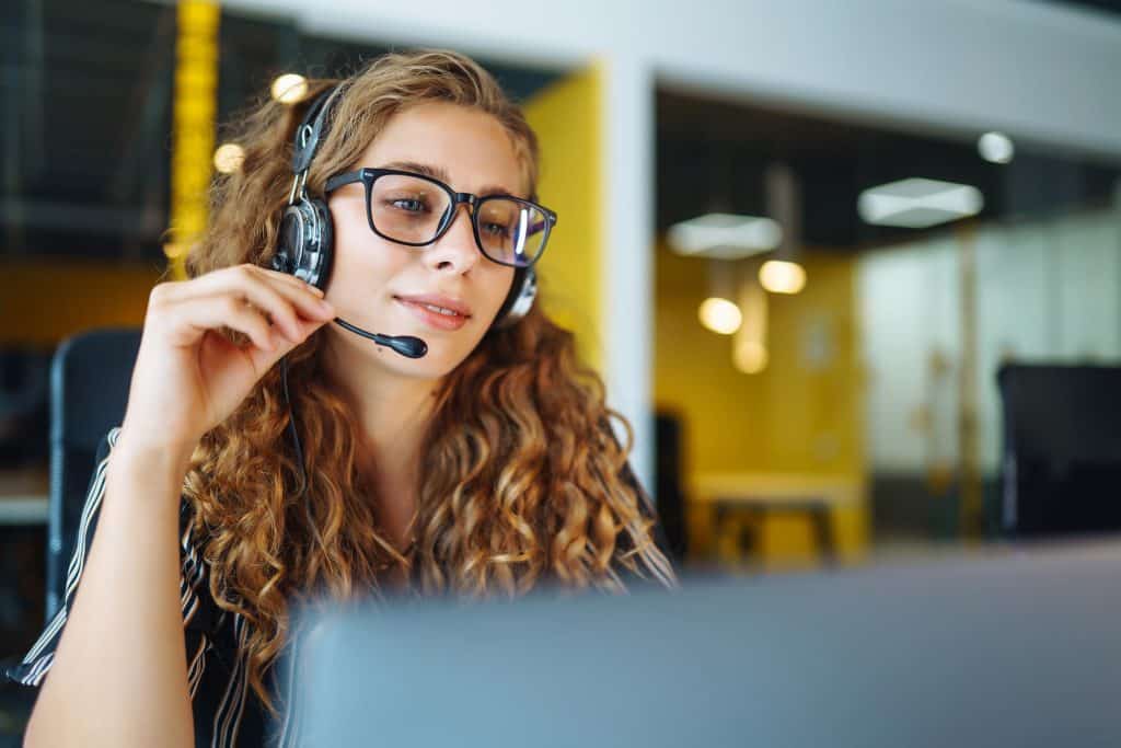 Meeting online. Young woman wearing headphones using laptop watching webinar or doing video chat.